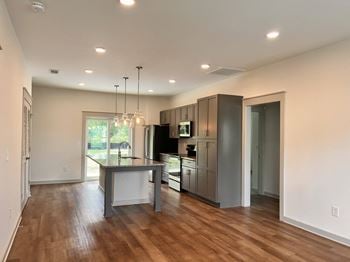 A modern kitchen with wooden floors and stainless steel appliances